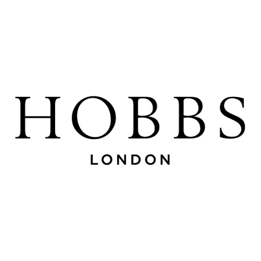 Woman wearing a Hobbs red bag and navy polka dot dress