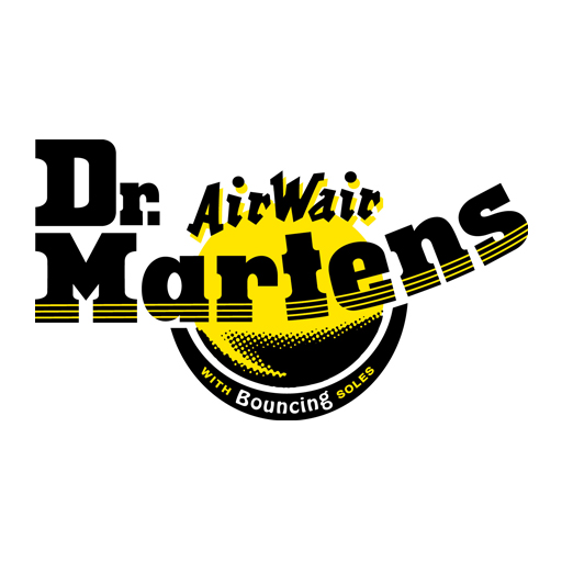 A pair of black leather Dr Martens boots featuring yellow stitching being worn on pebbles.
